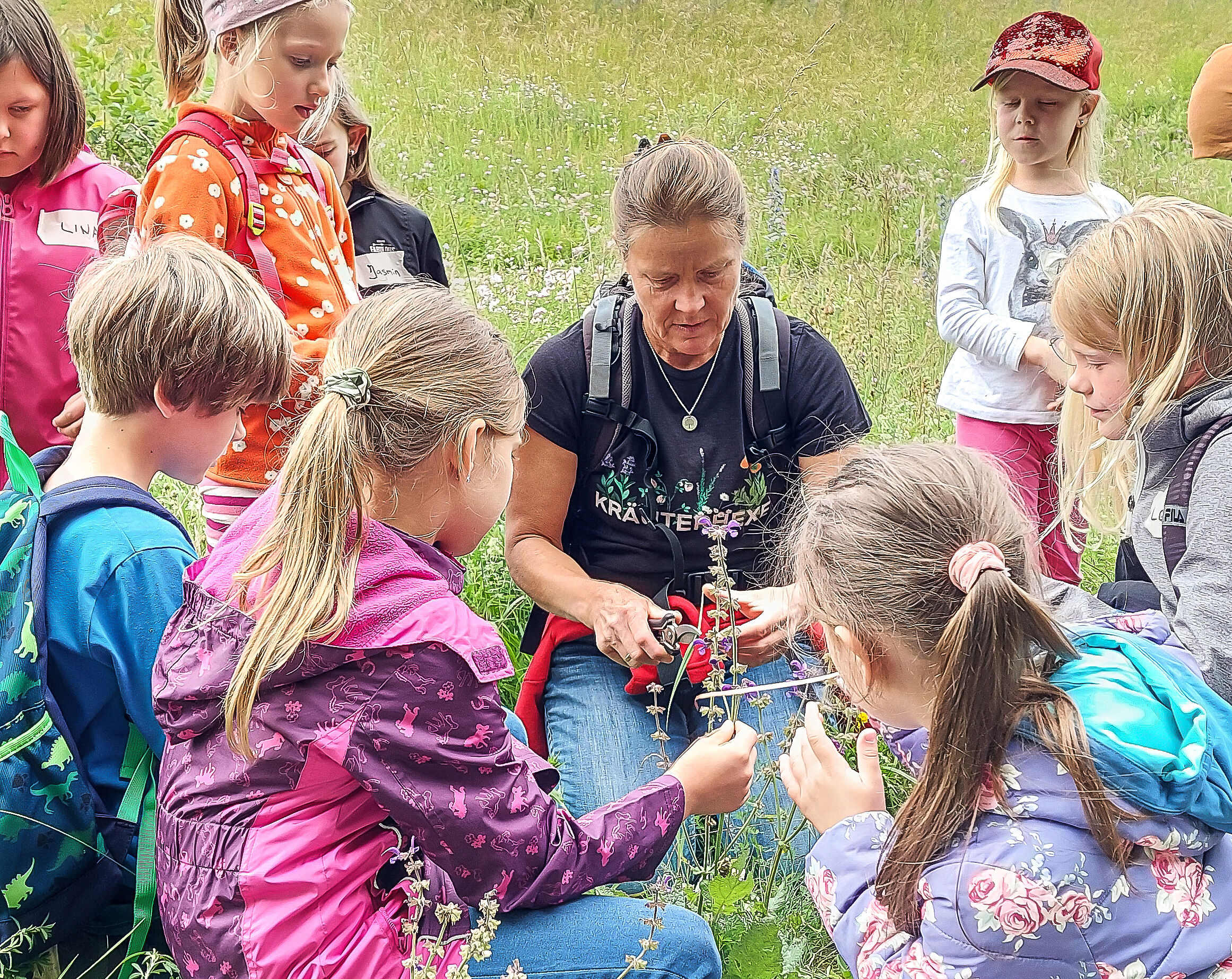 Kinder entdecken die wilde Welt der Pflanzen Niederviehbach. Großer Andrang herrschte bei einer von der Bund Naturschutz Ortsgruppe Niederviehbach für Kinder organisierten Kräuterwanderung mit der Kräuterpädagogin Sylvia Rabauer-Fuchs. Nach sehr kurzweiligen eineinhalb Stunden waren sich alle einig: die Pflanzenwelt steckt voller Geheimnisse! „Pflanzen muss man um Erlaubnis bitten, bevor man sie abschneidet“ so Rabauer-Fuchs. Sie plädiert dafür, den Pflanzen etwas mehr Aufmerksamkeit zu widmen. Denn ganz grundsätzlich gelte, dass auch Pflanzen Lebewesen seien und man keinem Lebewesen unnötig schaden solle. Bewaffnet mit einem Sammelkorb, Lupe, Schere und weiteren Utensilien zogen die jungen Kräuterfans dann los, um die Umgebung am Isardamm zu erkunden. Es war augenscheinlich, dass viele Pflanzen Hinweise auf Tiere in ihrem Namen tragen. Schafgarbe, Gänsefingerkraut, Taubenkropf-Leimkraut, Löwenzahn und Bärenklau – spaßig für die Kinder war es, die Namen der Pflanzen anhand von Tierstimmen zu erarbeiten. Viel Wissenswertes über die Kräuter konnte dabei auch vermittelt werden. Der blaue Natternkopf wurde so sprichwörtlich unter die Lupe genommen. Der Name dieser Pflanze leitet sich ab von seiner Blüte und ihren Griffeln, welche dem Kopf einer Natter ähnelt. Spannend wurde es dann beim Giersch. Er wächst bei uns fast überall, auch in den Hausgärten. Schnipp, schnapp bekam jedes Kind ein Stück des Stängels abgeschnitten. Einmal durchgeblasen und der Naturtrinkhalm ohne Plastik war fertig. Da wollten alle gleich testen, ob es denn wirklich als Trinkhalm funktioniert. Die Kräuterpädagogin Sylvia Rabauer-Fuchs verblüffte die Kinder mit einer besonderen Wildpflanze, dem Spitzwegerich. Diese sehr alte Heilpflanze ist gut zu erkennen an ihren länglich spitzzulaufenden Blättern. Sie sehen aus wie eine Lanze oder ein Schwert. Die Blüte ist braun und umgeben von weißen Staubgefäßen. Die Pflanze wächst gerne an oder auf Wegen und aus dem Blatt kann ein Wiesenpflaster gebastelt werden. „Bei Bienen- oder Wespenstichen hilft es gut, wenn man die Blätter des Wegerichs zerreibt und auf die Stichstelle auflegt“, so die kräuterkundige Rabauer-Fuchs. Es wurde noch mit den braunen verblühten Blütenständen des Klappertopfes gerasselt und der bei der Blüte des Wiesensalbeis konnte jedes Kind mit einem dünnen Grashalm den sogenannten „Klappmechanismus“ auslösen. Dadurch klappt das Staubgefäß nach unten und überträgt so den Pollen auf die Blüte besuchende Hummeln. Angeleitet von Rabauer-Fuchs konnte jedes Kind dieses Schauspiel testen. An diesem Nachmittag war deutlich zu spüren wie einerseits Kinder mit der Natur verbunden sind und andererseits diese interessiert wahrnehmen. Beim Abschlusskreis wurden nochmal alle neu entdeckten Wildpflanzen wiederholt und die Kinder freuten sich über ein kleines Abschiedsgeschenk, welches von der für die örtliche Ortsgruppen-Kinderarbeit zuständige Andrea Püls mit dem Hinweis auf eine BN-Ortsgruppen-App überreicht wurde.